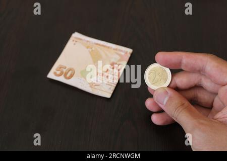 50 türkische Lira und 2 Euro auf schwarzem Hintergrund. Die Wertlosigkeit der türkischen Währung gegenüber der Fremdwährung Stockfoto