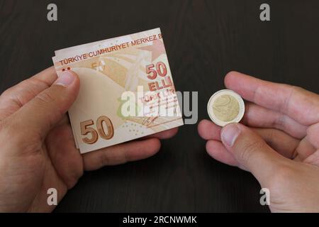 50 türkische Lira und 2 Euro auf schwarzem Hintergrund. Die Wertlosigkeit der türkischen Währung gegenüber der Fremdwährung Stockfoto