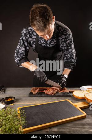 Saftiges, frisch gegrilltes Steak. Der Koch schneidet gebratenes Fleisch in Scheiben Stockfoto