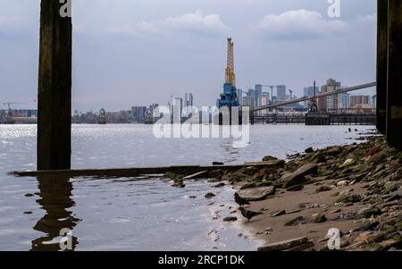 Industrie- und Stadtlandschaft an der Themse am Ufer von North Woolwhich mit Blick flussaufwärts zu den Zuckerraffineriekranen Tate und Lyle. UK Stockfoto