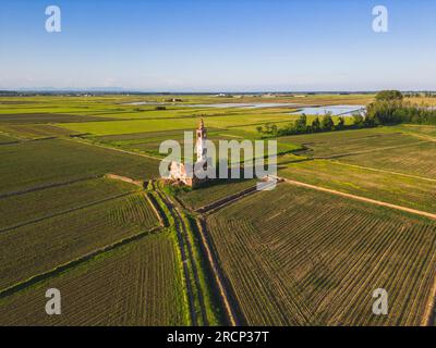 Luftaufnahme einer verlassenen Kirche in der Mitte der Weizenfelder mit Himmelsfeldern im Hintergrund. Novara, Piemont Stockfoto