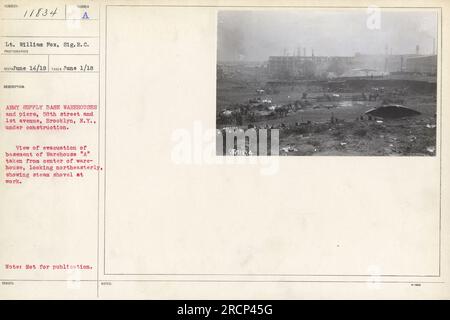 Leutnant William Fox, Sig. R.C., hat ein Foto von der Evakuierung des Untergeschosses von Warehouse A in der Army Supply Base in Brooklyn, New York, am 1. Juni 1918 aufgenommen. Das Bild zeigt eine Dampfschaufel in Aktion und bietet einen Blick auf die im Bau befindlichen Lager und Piers. Stockfoto