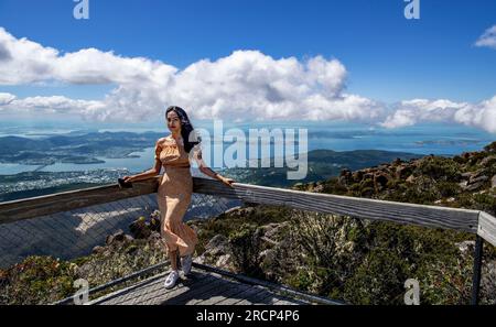 Hübsche junge Frau, die für ein Foto posiert am Aussichtspunkt Mount Wellington Hobart Tasmania Australia Stockfoto