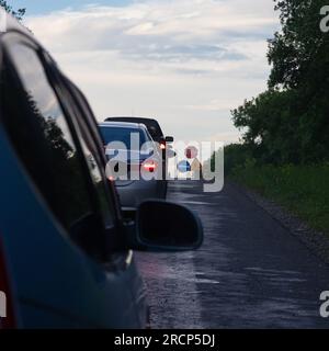 Verkehrsstaus auf der Straße sind mit der Reparatur der Straße verbunden. Guten Abend Stockfoto