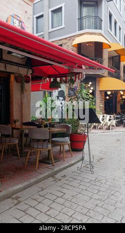 Straße im Karakoy Viertel von Istanbul mit einem Café/Restaurant und einer Charlie Chaplin Illustration an einer Wand Stockfoto