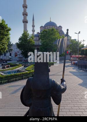 Statue und Wasser mit der Yeni Cami Moschee (neue Moschee) dahinter. Istanbul, Türkei Stockfoto