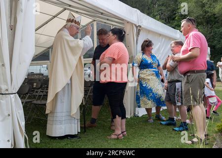 Open-Air-Kirche Service katholischer Bischof von Wrexham, der rechte Reverend Peter M. Brignall. Er segnet gläubige katholische irische Reisende nach dem Gottesdienst bei Saint Winefride's Feast Day Pilgrimage. Holywell, Flintshire, Wales, 25. Juni 2023. 2000S GB HOMER SYKES Stockfoto