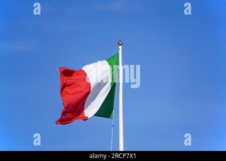 Italienische Flagge vor klarem blauem Himmel. Stockfoto
