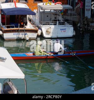 Ein männlicher Ruderlehrer spricht mit einer muslimischen Studentin in einem Ruderboot in Anadolu auf der asiatischen Seite von Istanbul, Türkei Stockfoto