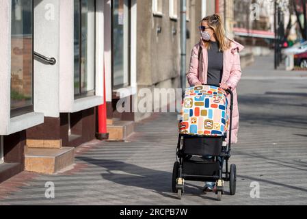 RUZOMBEROK, SLOWAKEI - 26. MÄRZ: Frau in Gesichtsmaske schiebt einen Kinderwagen in der Stadt 26. März 2020 in Ruzomberok Stockfoto