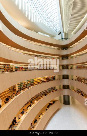 Zürich, Schweiz-27. Mai 2023; Vertikale Betrachtung von Studenten der Universität Zürich in der Bibliothek des Instituts für Recht im gebogenen, von einem Kamm umhüllten hölzernen Atrium Stockfoto