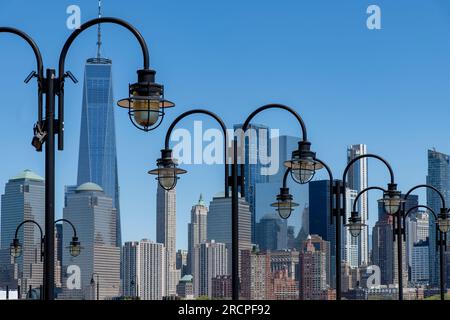 Jersey City, NJ, USA – Mai 2022; Nahaufnahme einer Reihe von Straßenlichtern mit alten Lampen entlang der Küste von Jersey City, NJ, USA mit dem Himmel von Lower Manhatten Stockfoto