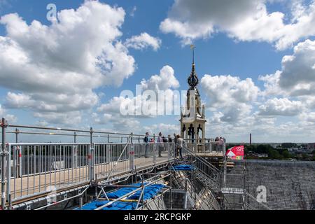 Gouda, Niederlande - Juni 2022; Blick auf Menschen, die auf Gerüstbauten auf dem Dach mit hölzernem Glockenturm der Johanniskirche laufen, während der Dachspaziergang Stockfoto