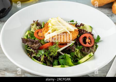 Frittierter Ziegenkäsesalat auf weißem Porzellanteller Stockfoto