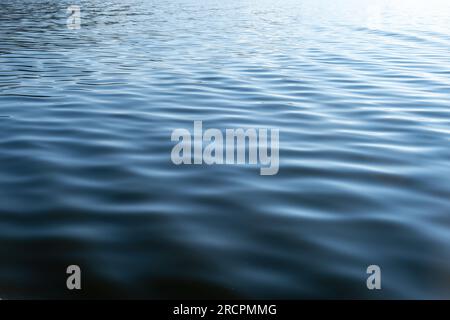 Meerwasser mit kleiner welliger Hintergrundtextur. Blaue Farbe der Ozeanoberfläche, abstrakter Hintergrund der bereinigten Umgebung, leere Vorlage, Kopierbereich Stockfoto