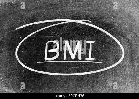 Weiße Kreidehand mit dem Wort BMI (Abkürzung für Body Mass Index) und Kreisform auf dem Hintergrund der Tafel Stockfoto