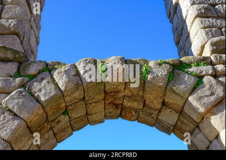 Segovia, Spanien - 11. Februar 2023: Römisches Aquädukt. Nahaufnahme eines Steinbogens im historischen Gebäude. Ziegelverlegungstechnik vergangener Zeiten. Stockfoto