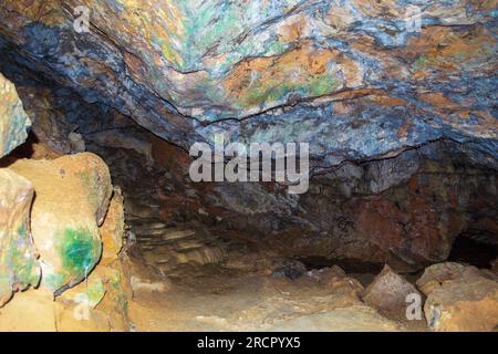 Farbenfrohe Steine der Zoodochos Pigi Höhle. Die natürliche Quelle in der Höhle ist die einzige Süßwasserquelle auf der Insel Santorin.Griechenland Stockfoto