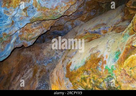 Farbenfrohe Steine der Zoodochos Pigi Höhle. Die natürliche Quelle in der Höhle ist die einzige Süßwasserquelle auf der Insel Santorin.Griechenland Stockfoto