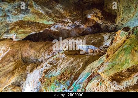 Farbenfrohe Steine der Zoodochos Pigi Höhle. Die natürliche Quelle in der Höhle ist die einzige Süßwasserquelle auf der Insel Santorin.Griechenland Stockfoto