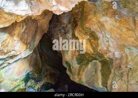 Farbenfrohe Steine der Zoodochos Pigi Höhle. Die natürliche Quelle in der Höhle ist die einzige Süßwasserquelle auf der Insel Santorin.Griechenland Stockfoto