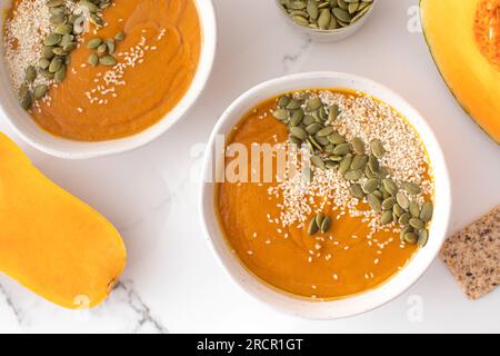 Teller mit Kürbissuppenpüree, Kürbis und Sesamsamen. Herbstmenü. Stockfoto