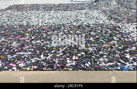 Fußböden aus recycelten Gummipartikeln. Schwarzer Polsterboden mit bunten Partikeln Stockfoto