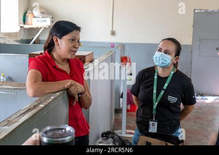 El Espino, La Libertad, El Salvador - Oktober 11 2022: Salvadorianische Frau in Rot spricht mit einer anderen Frau in Schwarz Stockfoto