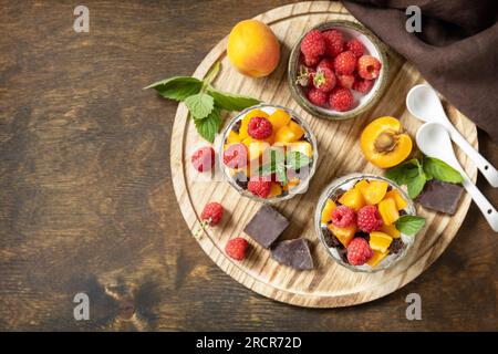 Ein paar Schokokekse mit Joghurt und frischen Beeren und Obst. Zwei Portionen Parfafait-Dessert aus Glas. Sommer gesunde Ernährung Frühstück, Snack Kontra Stockfoto