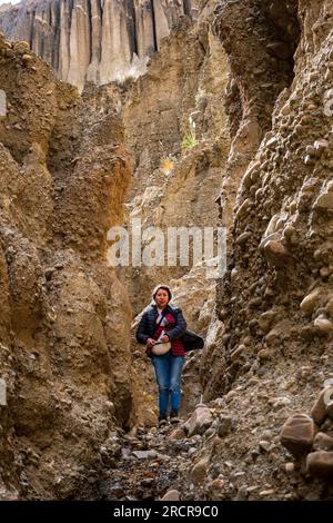 Palca, La Paz Bolivien - August 7 2022: Junge indigene Frau in Blue Jeans starrt auf die Linse in den Bergen von Valle de Las Animas (Spirits' Vall Stockfoto