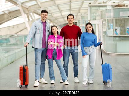 Zwei Glückliche Paare, Die Sich Mit Dem Gepäck Auf Dem Flughafen Posieren Stockfoto