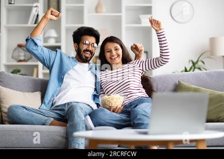 Ein indisches Paar, das sich zu Hause ein Fußballspiel ansieht Stockfoto