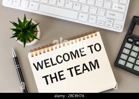 Willkommen im Team, Willkommensbrief auf dem Schreibtisch, Geschäftskonzept, Baugemeinde im Unternehmen, schöner grauer Hintergrund, Büroausstattung A. Stockfoto