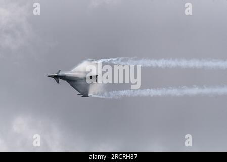 RAF Fairford, Gloucestershire, Vereinigtes Königreich. 16. Juli 2023. Die Royal International Air Tattoo ist eine der größten Flugshows der Welt, hat jedoch unter den extremen Wetterbedingungen am Freitag und Samstag in den Cotswolds gelitten. Der Sonntag der Veranstaltung ist viel besser geworden, da die militärischen Düsenjäger, Ausstellungsteams und andere Teilnehmer in den Himmel aufgestiegen sind. Die feuchte Luft verursachte Kondensation über den Flügeln der sich schnell bewegenden Düsen. Italienische Luftwaffe Eurofighter F-2000A Taifun von 311 Gruppo Volo Stockfoto