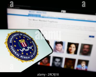 Mobiltelefon mit Siegel des US Federal Bureau of Investigation (FBI) auf dem Bildschirm vor der Website. Konzentrieren Sie sich auf die Mitte des Telefondisplays. Stockfoto