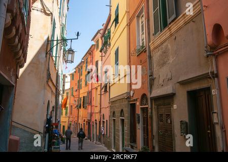 Portovenere Italien - 27 2011. April; schmale, farbenfrohe, schattige Straße mit hohen Gebäuden. Stockfoto