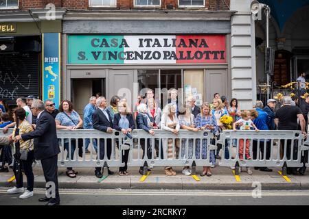 London, Großbritannien. 16. Juli 2023 Die Menschen beobachten die Prozession unserer Lieben Frau vom Berg Carmel, beginnend bei der italienischen Kirche St. Peter und dann durch die Straßen von Clerkenwell. Die Schwimmwesten zeigen lebensgroße Darstellungen biblischer Szenen in einem römisch-katholischen Festival, das seit den 1880er Jahren jährlich in der Gegend stattfindet, die einst das kleine Italien der Hauptstadt war. Kredit: Stephen Chung / Alamy Live News Stockfoto