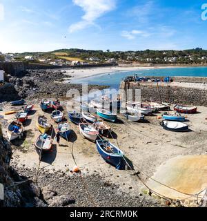 COVERACK, CORNWALL, GROSSBRITANNIEN - 7. JULI 2023. Landschaftsblick auf traditionelle kornische Fischerboote, die im Gezeitenhafen des malerischen Fischerdorfes festgemacht sind Stockfoto