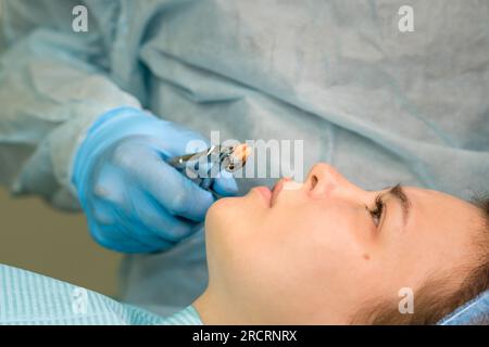 Die Hand des Zahnarztchirurgen hält in der Zange einen frisch entfernten Weisheitszahn oder Drittmolar. Echte Prozedur. Nahaufnahme Stockfoto