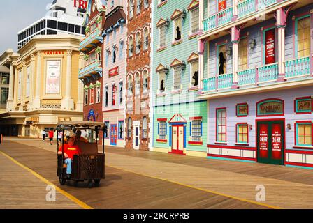 Ein Pedicab bringt einen Passagier an den Kasinos entlang der Promenade von Atlantic City, New Jersey vorbei Stockfoto