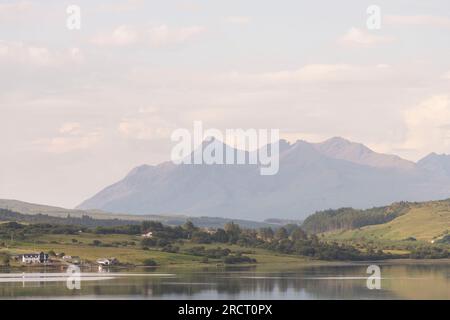 Blick von Portree nach Süden über Loch Portree auf die Red Cuillin Peaks an einem sonnigen Sommermorgen Stockfoto