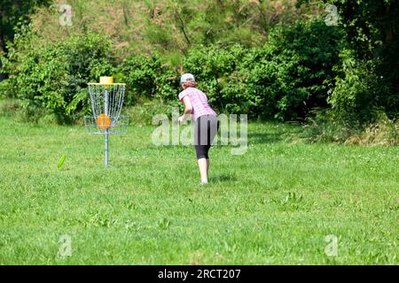 Junge Frau spielt fliegende Scheibe Sport-Spiel im Park Stockfoto