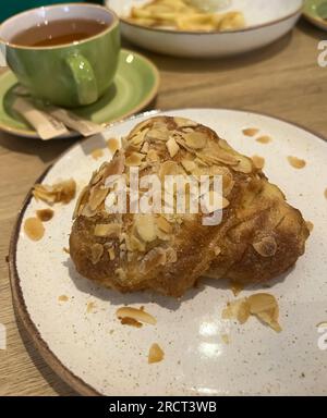 Frisch gebackene Mandelcroissants und Tee Stockfoto