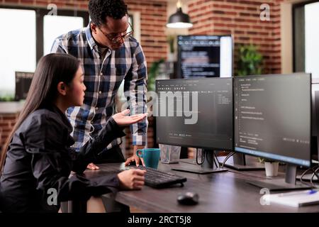Vielfältiges Team von Systemingenieuren, die HTML-Code und Cloud-Computing in der IT-Entwicklungsagentur entwickeln. Asiatischer Softwareentwickler, der auf der Tastatur ein Skript für künstliche Intelligenz erstellt. Stockfoto