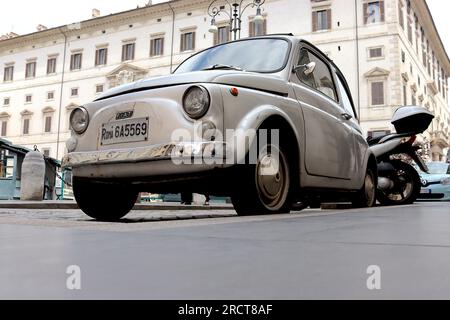 Ein Beweis für jahrelange Fahrten durch die Straßen Roms, ein originaler Fiat 500 in gut verwendetem Zustand trotz sichtbarer Dellen, bleibt ein Überlebender. Stockfoto