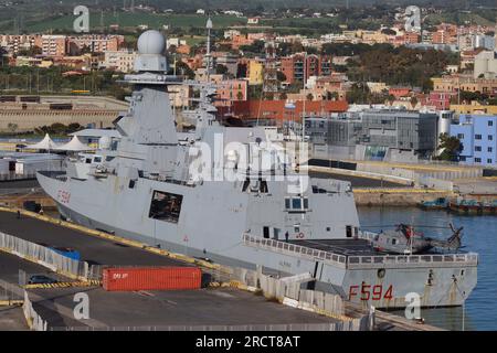 Die italienische Marinefregatte Alpino, Wimpel Nummer F 594 mit einem ihrer zwei NH90-Hubschrauber, im Hafen von Civitavecchia, Italien, im April 2023 festgemacht. Stockfoto