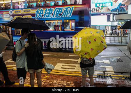 Hongkong, China. 16. Juli 2023. Die Leute laufen mit Sonnenschirmen auf der Straße. Am 16. Und 17. Juli bereitete sich Hongkong auf die Ankunft des Taifuns Talim vor, da die Stadt das T8-Warnsignal vom Hong Kong Observatory zum ersten Mal im Jahr 2023 ausgab. Wenn sich der Sturm nähert, spüren Sie die Auswirkungen in verschiedenen Teilen der Stadt, einschließlich Tsim Sha Tsui und Heng Fa Chuen, wo die Bewohner die Macht des Taifuns erleben. Kredit: SOPA Images Limited/Alamy Live News Stockfoto