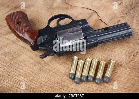 Revolvergewehr mit Munition auf dem Holzhintergrund Stockfoto