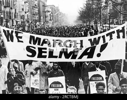 New York, New York: 15. März 1965 Bürgerrechtler mit einem Banner: "Wir marschieren mit Selma!" Führe den Weg, während 15.000 Leute eine Harlem Street hinunterfahren. Stockfoto