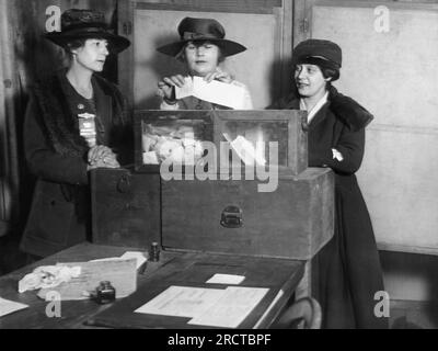 New York, New York: ca. 1917 drei Wahlrechtsnachfolger geben Stimmen in New York City ab. Die Originalunterschrift lautete: "Beruhigen Sie sich. An der 56. Und Lexington Avenue zeigten die Wählerinnen keine Ignoranz oder Angst, sondern gaben ihre Stimmzettel auf eine sachliche Weise ab, die eine maßgeschneiderte Studie des Wahlrechts darstellt." Stockfoto